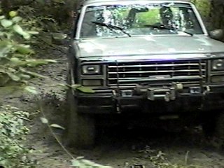 1980 Ford Bronco - A 1980 Ford Bronco navigates a challenging, muddy off-road path.