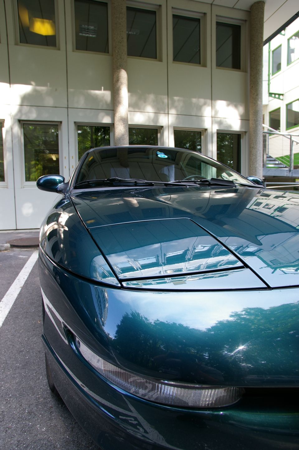 1997 Ford Probe front corner, dark green paint, parked outside building