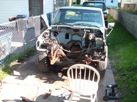 1990 Ford Ranger - This truck is missing its engine and front body panels, indicating it is undergoing repairs or a rebuild.