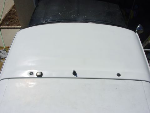 1994 Ford Bronco - The image shows the roof of a white SUV with a black top, a small antenna and a light.