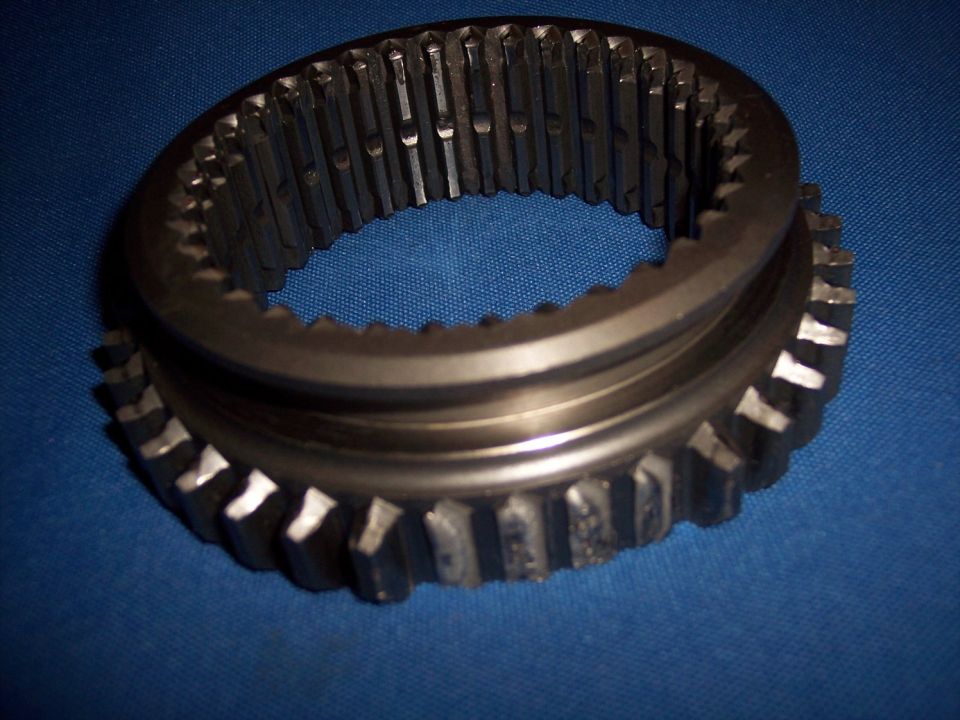Metal gear synchronizer ring with internal and external teeth, on a blue background