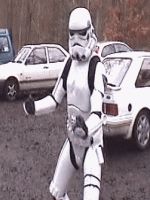 1991 Ford Bronco - A person in a Star Wars Stormtrooper costume stands in front of parked cars.