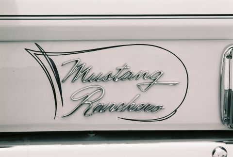 1973 Ford Ranchero - Close-up of a 'Mustang Ranchero' emblem on a white vehicle body panel.