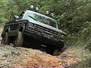 1980 Ford Bronco - This 1980 Ford Bronco navigates a challenging off-road course, equipped with auxiliary lights for enhanced visibility.