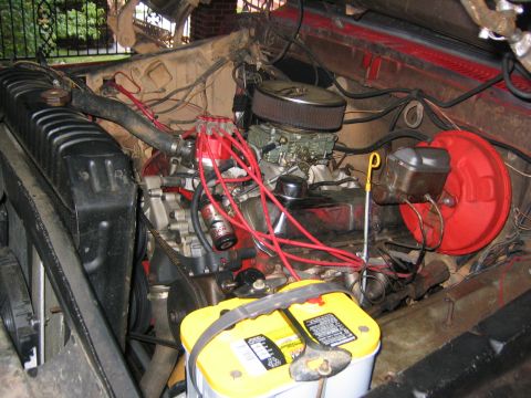1979 Ford Bronco - The engine bay of a 1979 Ford Bronco shows a V8 engine, carburetor, and battery.