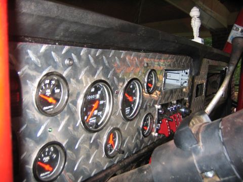 1979 Ford Bronco - Interior view of a custom dashboard multiple gauges and red toggle switches.