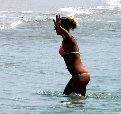 1991 Ford Bronco - Woman in a bikini stands in the ocean with waves around her.