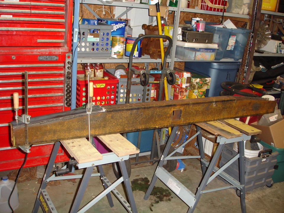 Rusty metal beam clamped and on sawhorses