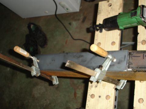 1989 Ford Bronco - Metal fabrication in progress, with clamps holding a piece of metal on a workbench.