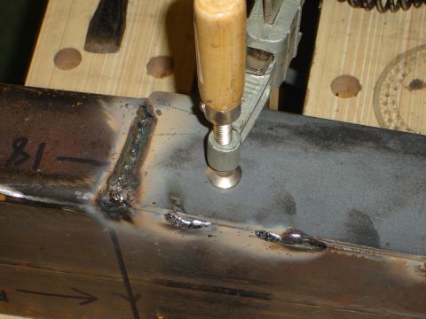 1989 Ford Bronco - Close-up of metal frame being welded, with a clamp holding it in place.