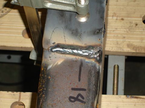 1989 Ford Bronco - A metal bracket is shown with a fresh weld and markings indicating '18'.