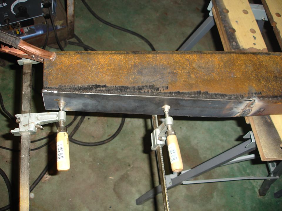 Metal beam being welded, clamped in place