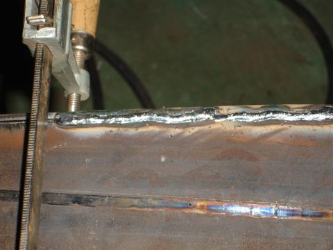 1989 Ford Bronco - Close-up of metal parts being welded, secured by a clamp.