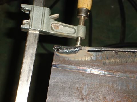 1989 Ford Bronco - Close-up of a clamp securing metal pieces for welding, with the SuperMotors logo in the corner.