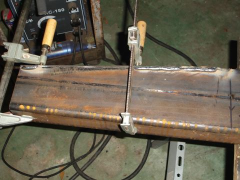 1989 Ford Bronco - Metal beam clamped in place for welding, with a welding machine visible.