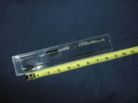 1998 Ford Crown Victoria - A car antenna is shown in its packaging alongside a measuring tape.