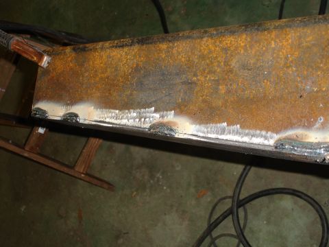 1989 Ford Bronco - Welding work in progress on a rusty metal beam, with the Supermotors logo in the corner.