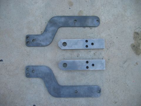 1985 Toyota 4Runner - Four metal brackets are laid out on a concrete surface, likely for vehicle modification or repair.
