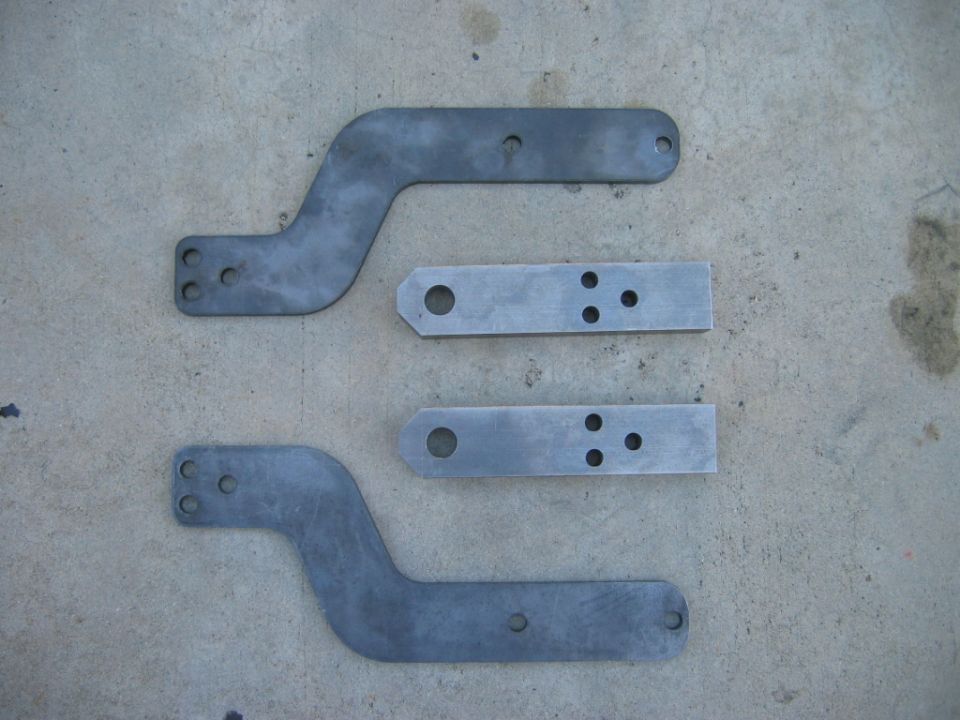 two bent metal brackets and two straight metal brackets with holes