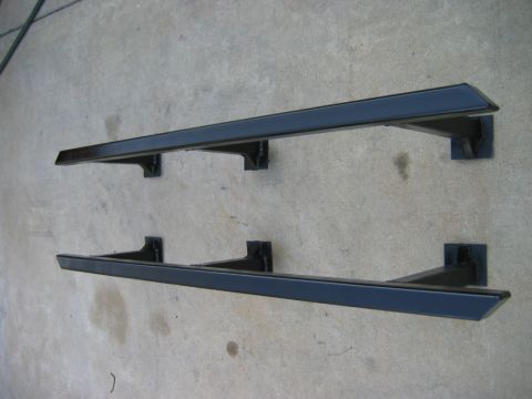 1985 Toyota 4Runner - Pair of black running boards shown mounted on a concrete surface, likely for sale or storage.