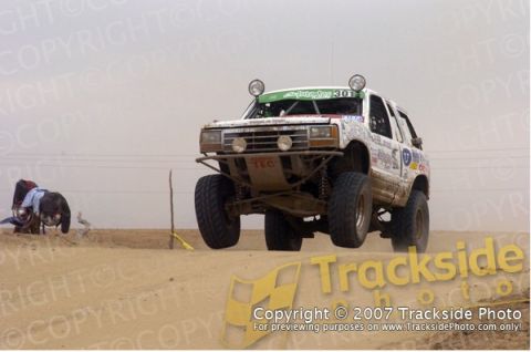 1992 Ford Explorer - Modified 1992 Ford Explorer competes in a desert race, kicking up dust.