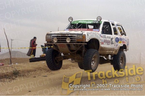 1992 Ford Explorer modified for off-road racing, airborne over a dirt track