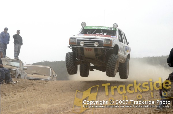 1992 Ford Explorer mid-air jump, front 3/4 view, white with racing decals