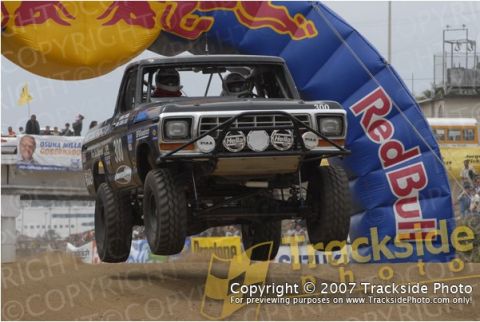 1992 Ford Explorer - This modified pickup truck is airborne, passing under a Red Bull sponsored archway during a race.