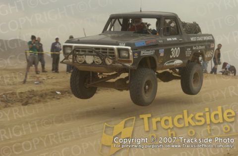 1992 Ford Explorer - Modified black truck airborne during a race, showing off its off-road capabilities.