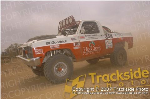 1992 Ford Explorer - This modified truck is participating in an off-road race, kicking up dust as it goes.