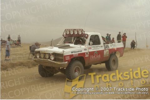 1992 Ford Explorer - A modified truck competes in an off-road race, with spectators in the background.