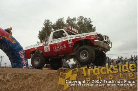 1992 Ford Explorer - A custom off-road truck competes in a race, jumping over a dirt obstacle.