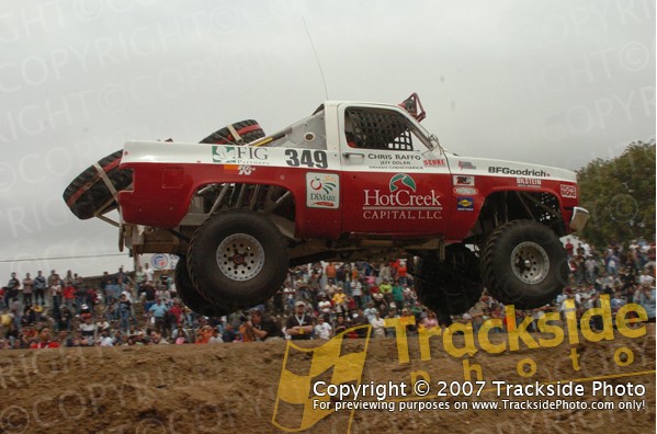 off-road truck mid-air with spare tires on back, number 349 on door