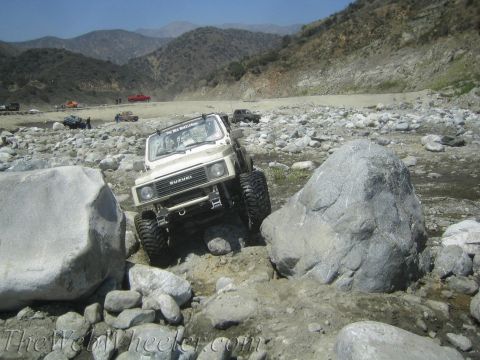 1987 Suzuki Samurai - Suzuki Samurai tackling a challenging rocky obstacle course.