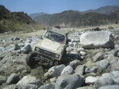 1987 Suzuki Samurai - Suzuki Samurai tackling a challenging rocky terrain during an off-road excursion.