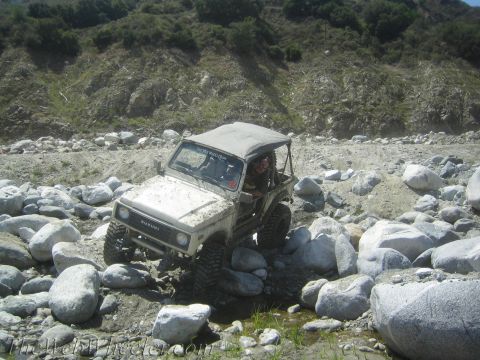 1987 Suzuki Samurai - A 1987 Suzuki Samurai tackles a challenging rocky terrain, demonstrating its off-road capabilities.