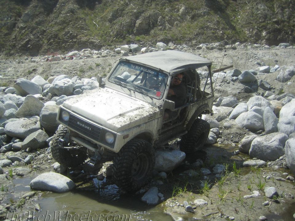 White 1987 Suzuki Samurai navigating rocky terrain