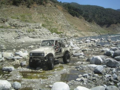 1987 Suzuki Samurai - A 1987 Suzuki Samurai navigates a rocky riverbed, its off-road capabilities.