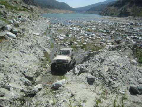 1987 Suzuki Samurai - This 1987 Suzuki Samurai navigates a challenging off-road course near a large body of water.