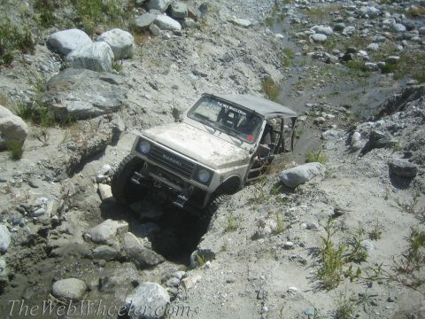 1987 Suzuki Samurai - Suzuki Samurai tackling rough terrain in a rocky, dry stream bed.