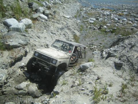1987 Suzuki Samurai - This 1987 Suzuki Samurai is shown tackling a challenging off-road trail with steep, rocky inclines and water obstacles.