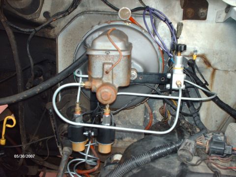 1982 Ford F-100 - Close-up view of the brake master cylinder and booster assembly, showing brake lines and electrical connections.