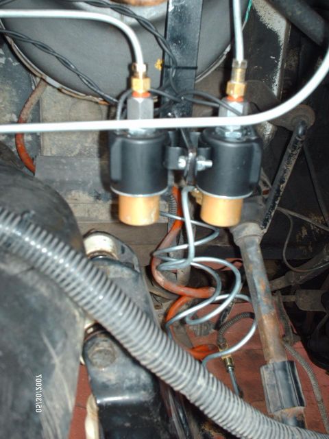 1982 Ford F-100 - Underside view of solenoid valves and associated plumbing within a vehicle's engine compartment.