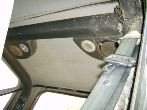2004 Jeep Wrangler - Overhead speakers and seatbelt visible inside a Jeep Wrangler.