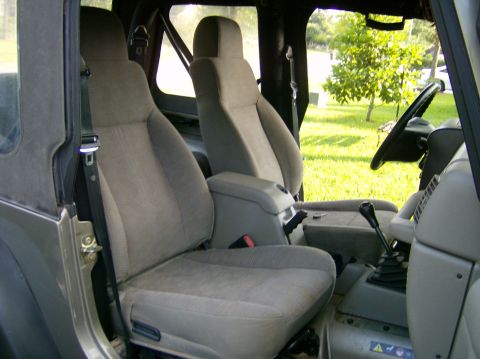 2004 Jeep Wrangler - Interior view of a Jeep Wrangler, showing the front seats, dashboard, and gear shifter.