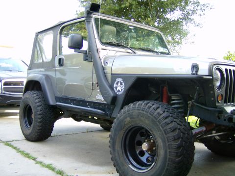 2004 Jeep Wrangler - This modified Jeep Wrangler features a prominent snorkel and tires, suggesting off-road capabilities.