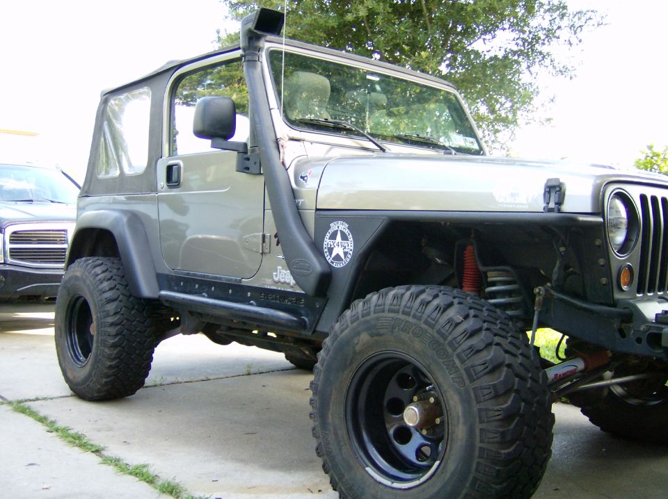 Silver Jeep Wrangler with snorkel and off-road tires