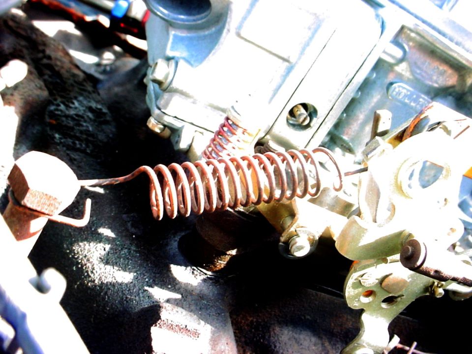 Close-up of a rusty spring on an engine carburetor linkage