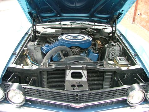 1970 Ford Ranchero - The engine bay of a blue 1970 Ford Ranchero, its V8 engine and prominent air cleaner assembly.