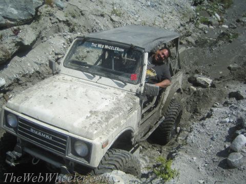 1987 Suzuki Samurai - Driver smiles as his 1987 Suzuki Samurai gets stuck in a muddy off-road trail.
